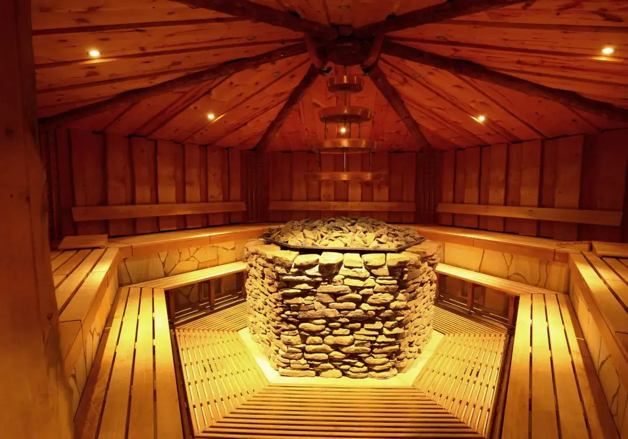 Gemütliche h2o sauna aus Holz mit Steinofen und Sitzbänken.