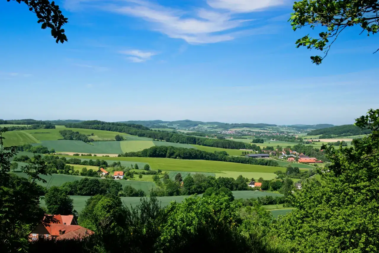 Gr&uuml;ne H&uuml;gel und Felder, ges&auml;umt von B&auml;umen, bilden einen malerischen weg der blicke. Kleine D&ouml;rfer schmiegen sich in die Landschaft.
