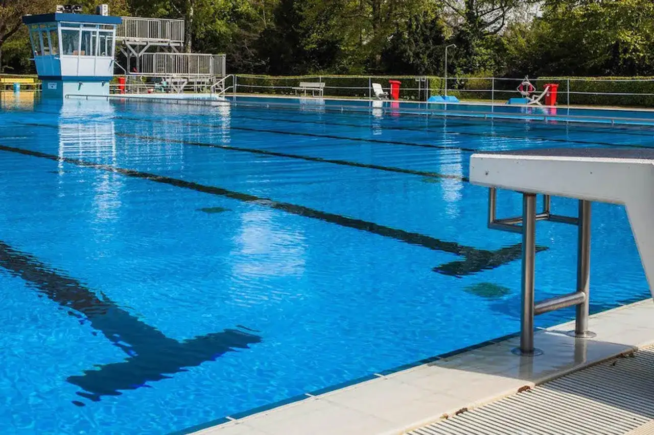 Das leere Freibad Rheda l&auml;dt mit seinem klaren blauen Wasser und den Sprungbrettern zum Schwimmen ein.