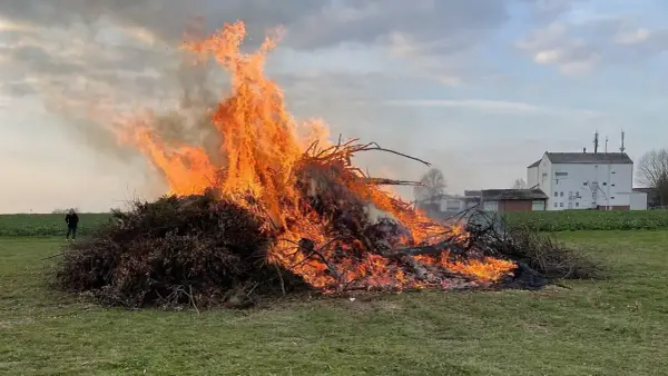 Großer Osterfeuer-Brauch: Ein Mann beobachtet die Flammen. Typische Oster Veranstaltungen.