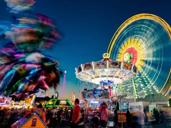 Buntes Treiben am Familientag Kirmes mit Karussells, Riesenrad und Lichtern.