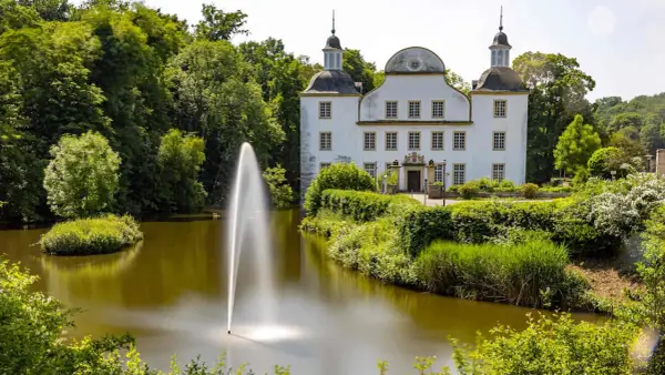 Schloss mit Wasserspielen und grüner Parkanlage, ein idyllischer Ort zum Entspannen und Genießen. Ein schönes Ziel in der Nähe von Essen Stadt.