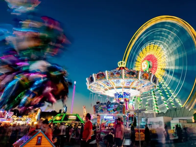 Buntes Treiben am Familientag Kirmes mit Karussells, Riesenrad und Lichtern.
